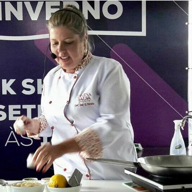 Chef Saly Goedert preparando receita em evento gastronômico